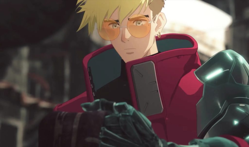 Trigun Stampede Ep. 5 "Child of Blessing" screenshot showing Vash staring pensively at a tattered piece of cloth in the ruined village.