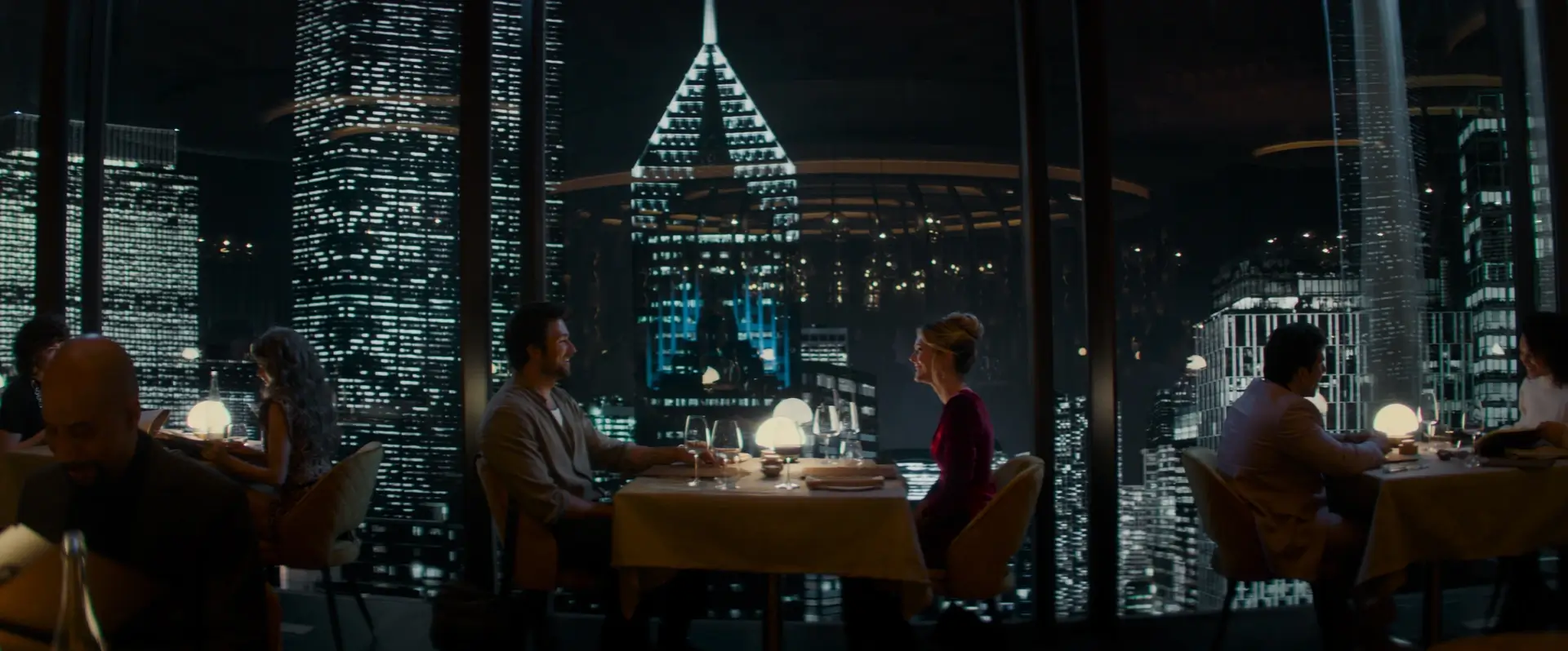 Henry (Brandon Sklenar) and Violet (Meghann Fahy) seated at a restaurant table in Drop