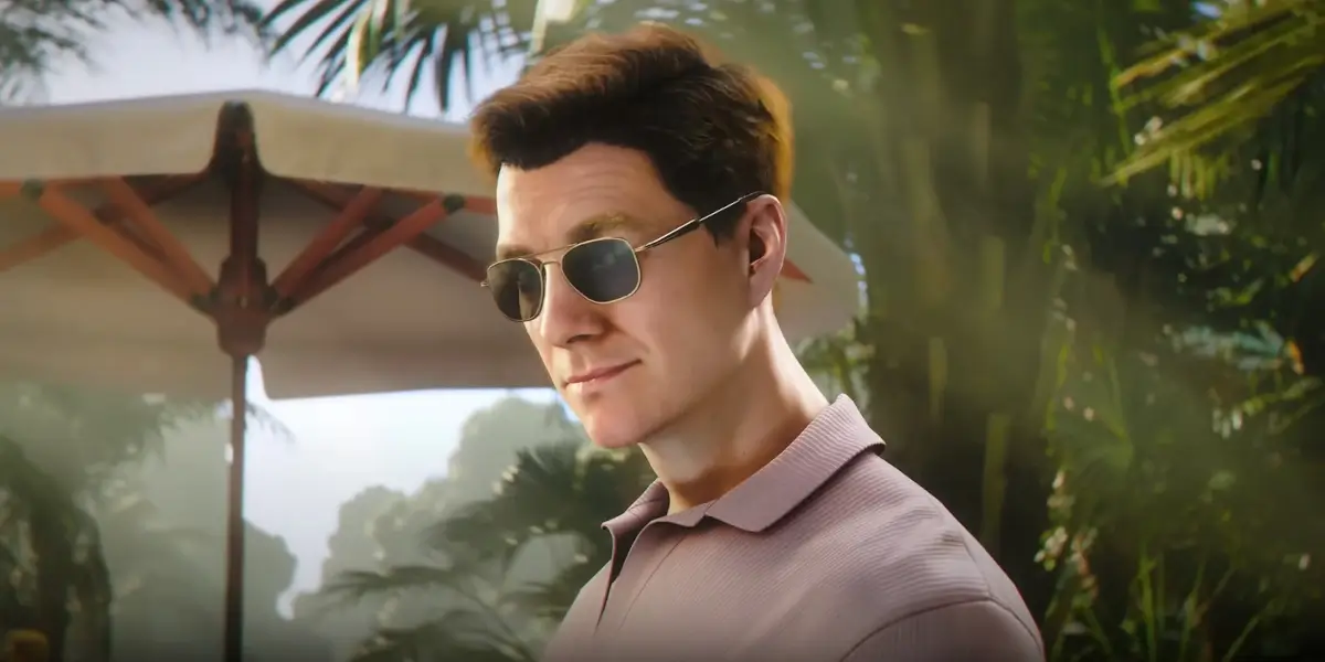 Patrick Gibson stands smirking at a resort, in sunglasses, for 007: First Light.