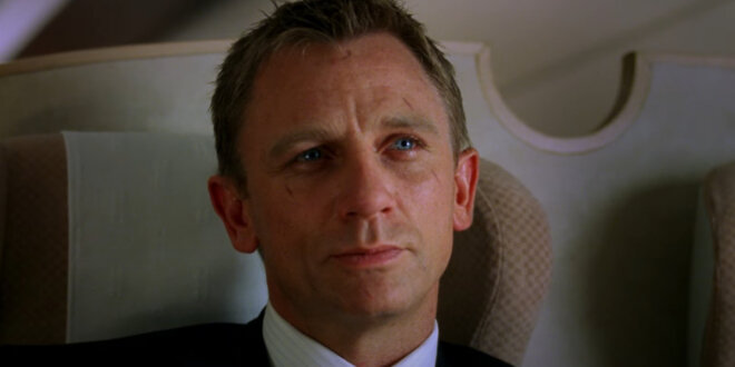 Daniel Craig smiles wryly as he sits in a dining car, in Casino Royale.