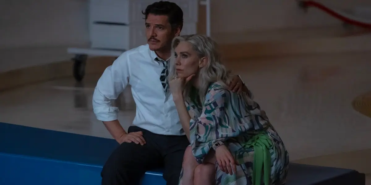 Pedro Pascal and Vanessa Kirby sit watching a screen in a dimly lit room in The Fantastic Four: First Steps.