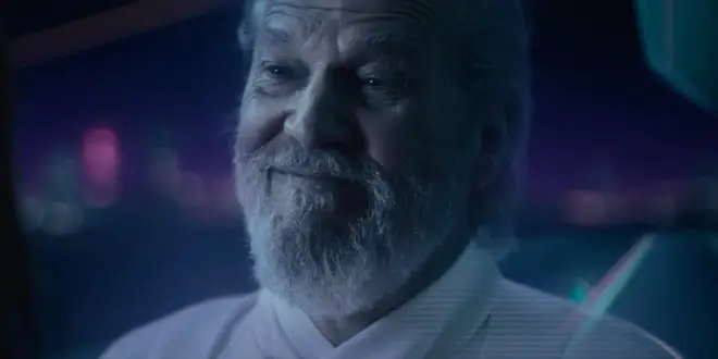 Jeff Bridges smiles as he stands on the Classic Grid in Tron: Ares.