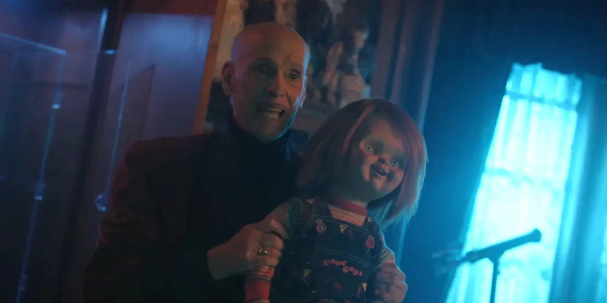 Chucky S3 John Waters Holds An Original Chucky Doll In An Ominous Room