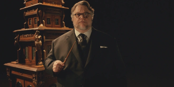 Guillermo del Toro stands holding a wand in hand in Guillermo Del Toro's Cabinet Of Curiosities.