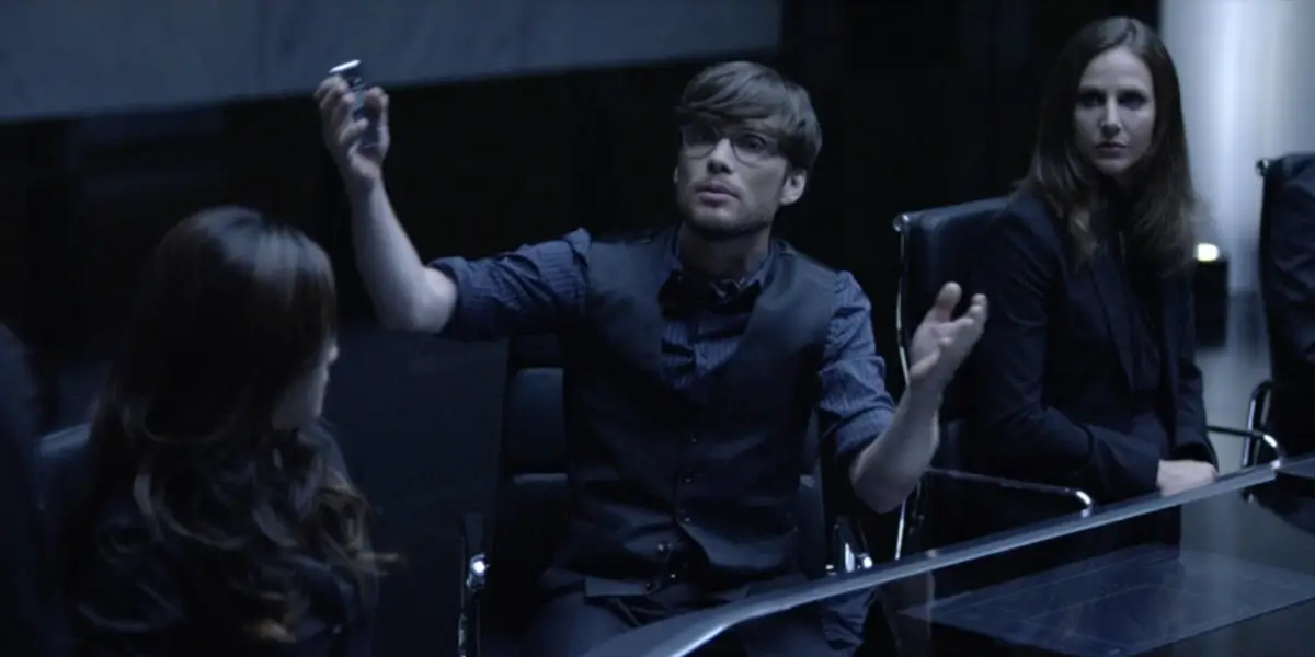 Tron Legacy Cillian Murphy Gestures Widely In A Dimly Lit Board Room