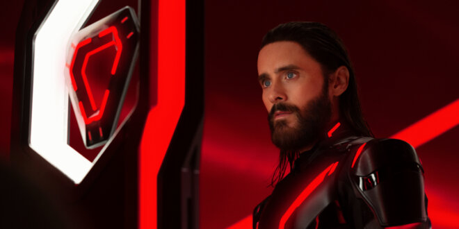 Jared Leto stares intently at his triangle shaped ID disc in Tron: Ares.