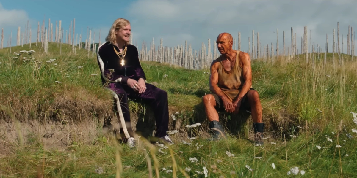 Jack O'Connell and Ralph Fiennes sit together in the sun in 28 Years Later: The Bone Temple.