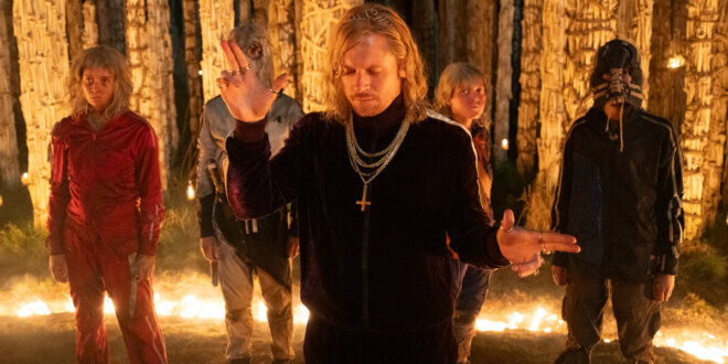Jack O'Connell stands in front of the Jimmy Gang in a meditative pose in 28 Years Later: The Bone Temple.