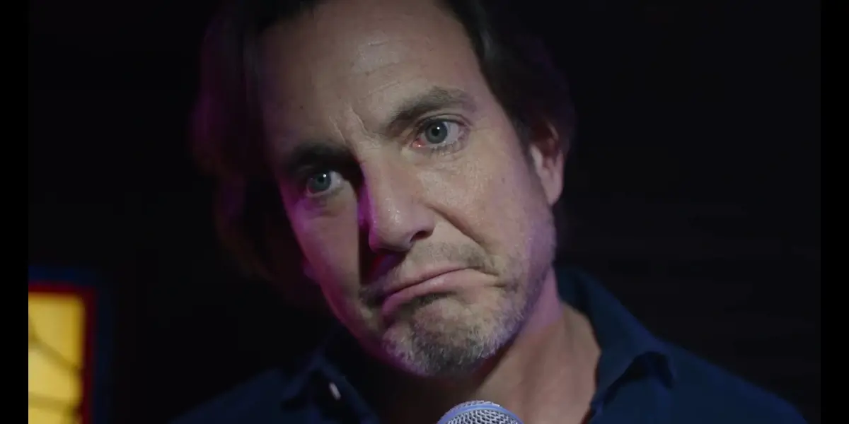 Will Arnett stands at the mic with a forlorn look in Is This Thing On.