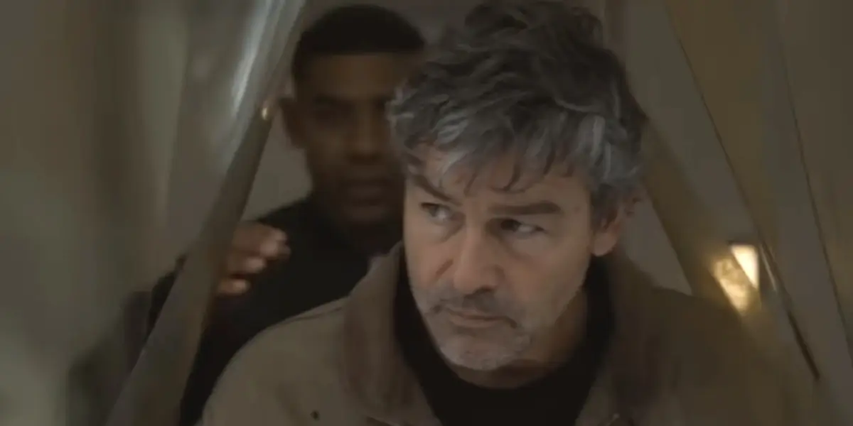 Kyle Chandler makes his way past a plastic curtain with Aaron Pierre following him in Lanterns.