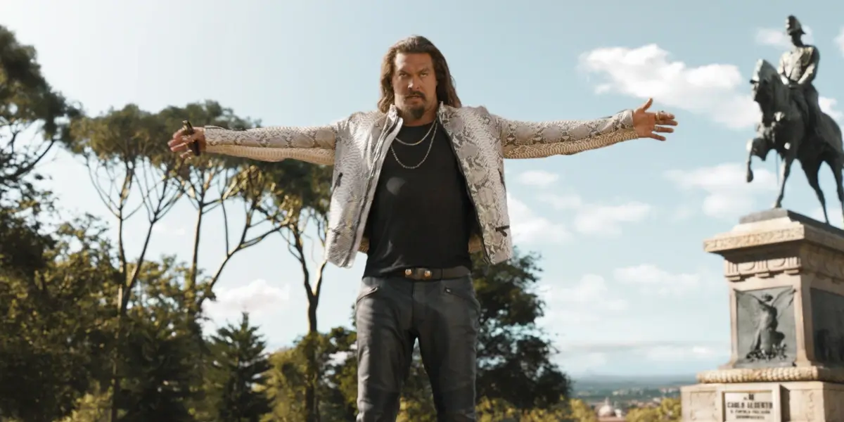 A menacing Jason Momoa stands outside with his arms wide open in Fast X.