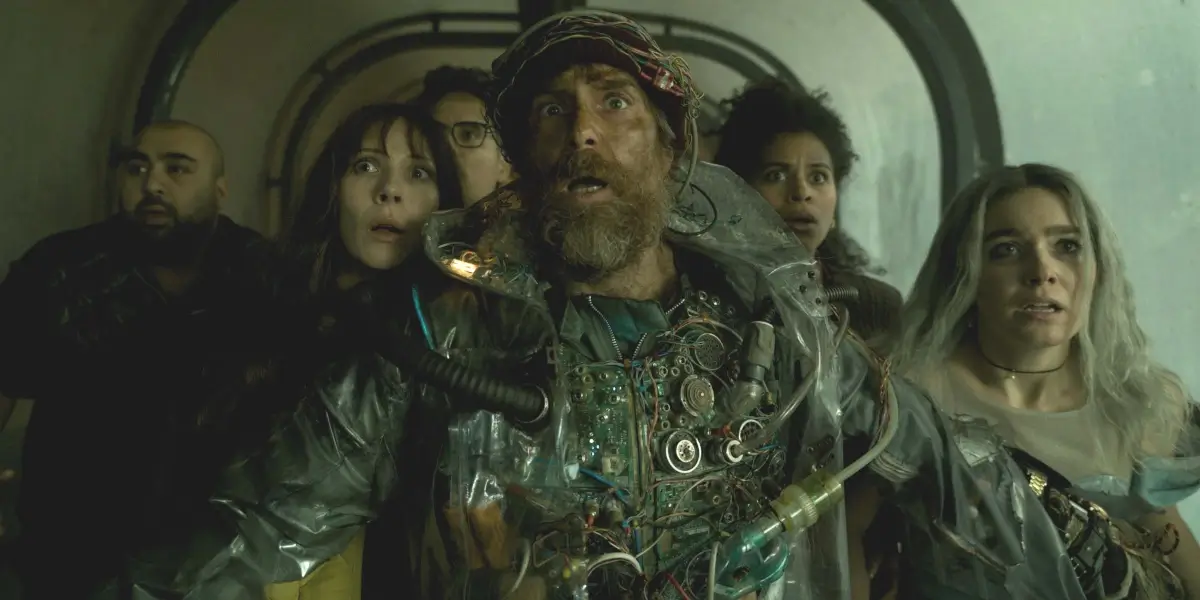 A frightened Sam Rockwell stands in front of a group of similarly terrified castmates in Good Luck, Have Fun, Don't Die.