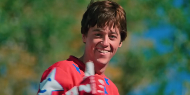 A smiling Bill Allen stands in racing gear and gives a thumb up in the trailer for Rad.