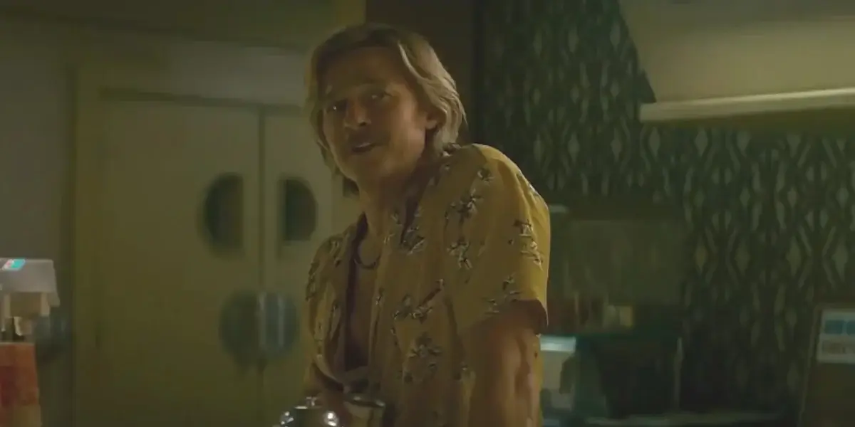 Brad Pitt smiles as he stands at the bar in The Adventures of Cliff Booth.