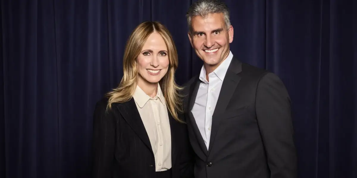 The Walt Disney Company's Dana Walden and Josh D'Amaro pictured together in front of a blue curtain