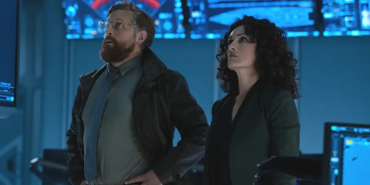 Joe Tippett and Mirelly Taylor look up with concern in Monarch's control room in Monarch: Legacy of Monsters - S2 E1 "Cause and Effect."