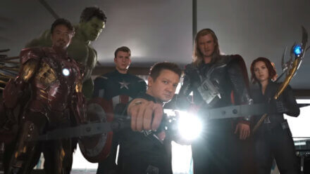 The Avengers' founding lineup stands menacingly in Stark Tower with Jeremy Renner in the center, drawing his bow.