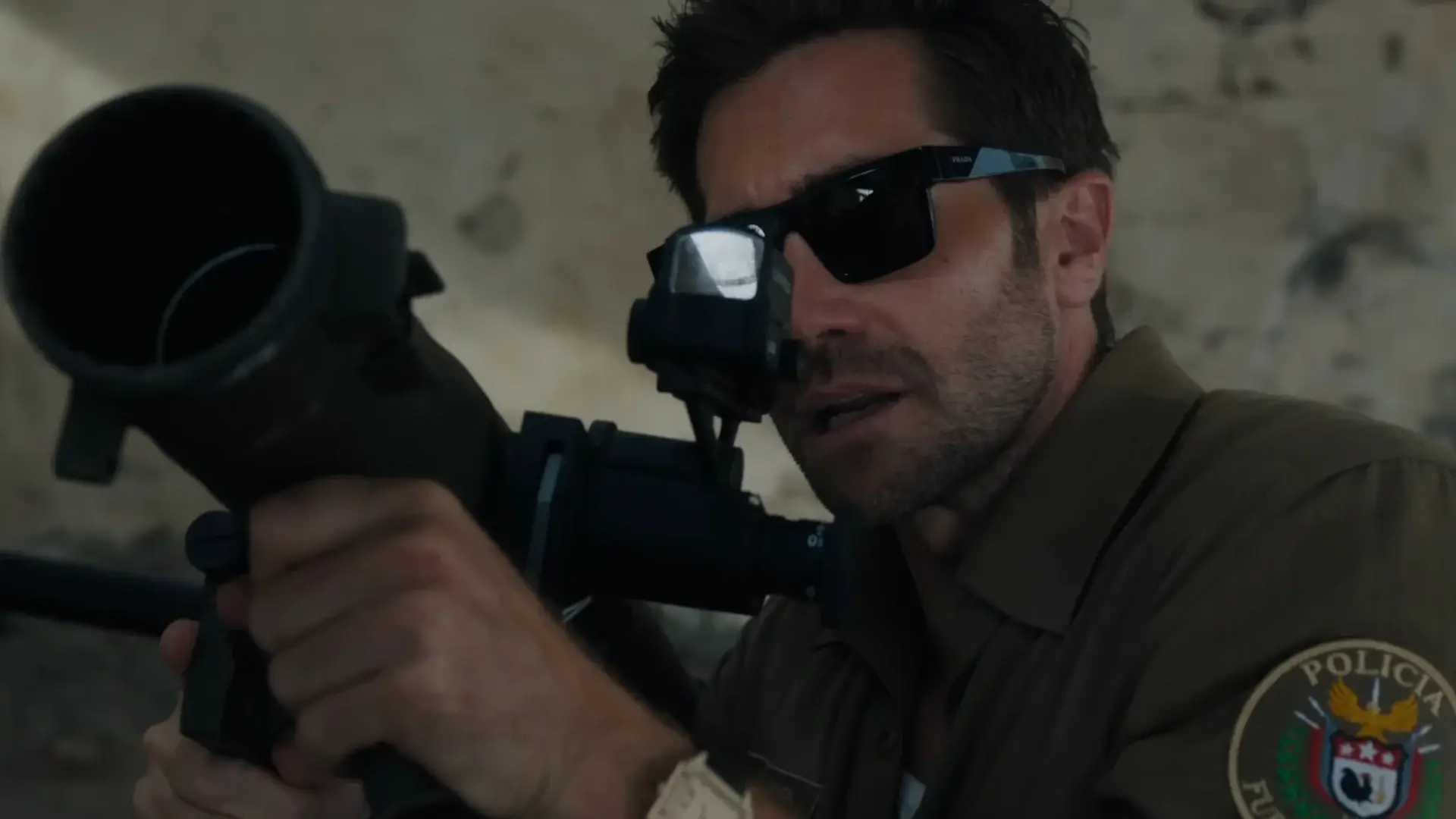 A crouched Jake Gyllenhaal aims a rocket launcher patiently in In the Grey.
