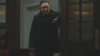 Tom Hardy stands menacingly in a doorway in MobLand S1 E10 - "The Beast In Me."