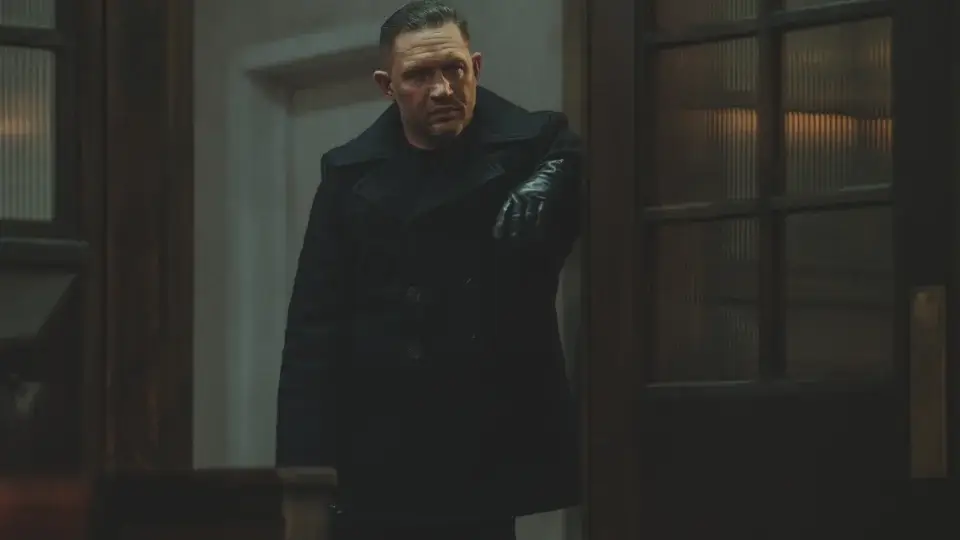 Tom Hardy stands menacingly in a doorway in MobLand S1 E10 - "The Beast In Me."