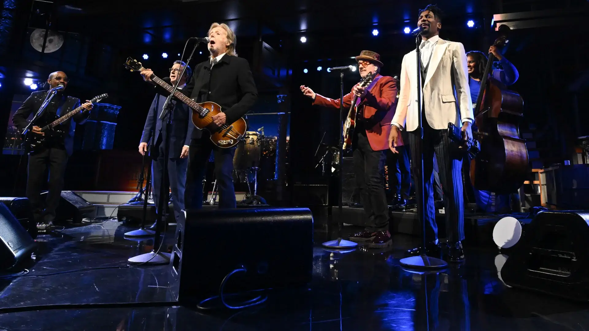 Louis Cato, Stephen Colbert, Sir Paul McCartney, and Elvis Costello and Jon Baptiste stand together singing on stage in The Late Show With Stephen Colbert's finale.
