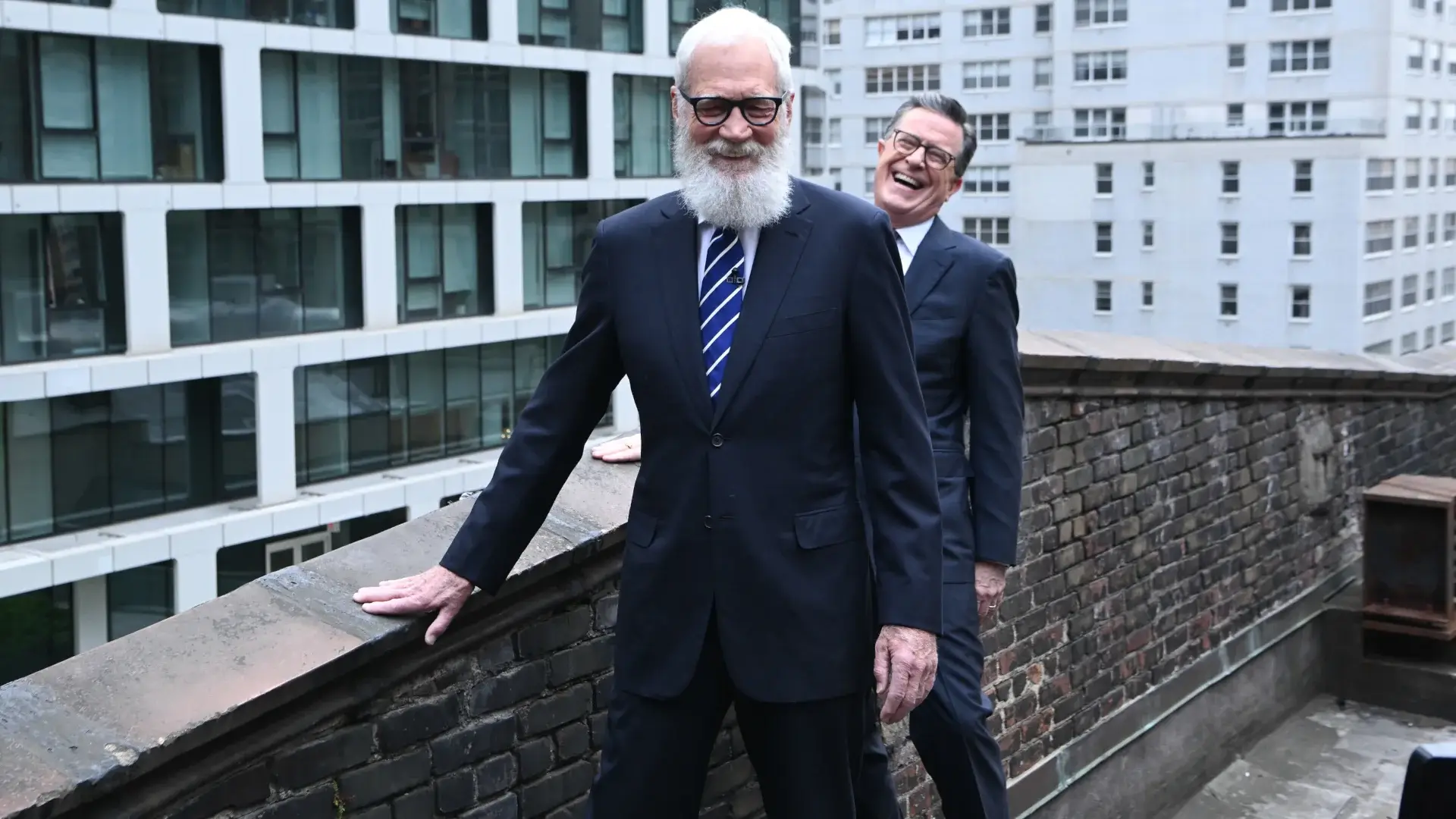 David Letterman and Stephen Colbert stand laughing together on the Ed Sullivan Theater's roof on The Late Show with Stephen Colbert.