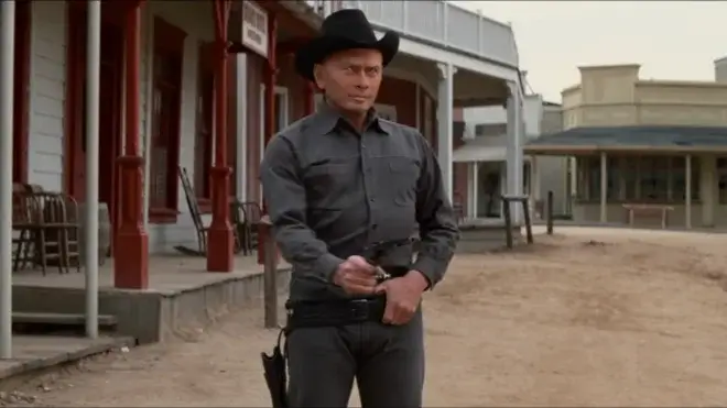 A menacing Yul Brenner stands in the middle of town with a gun drawn in Westworld (1973).