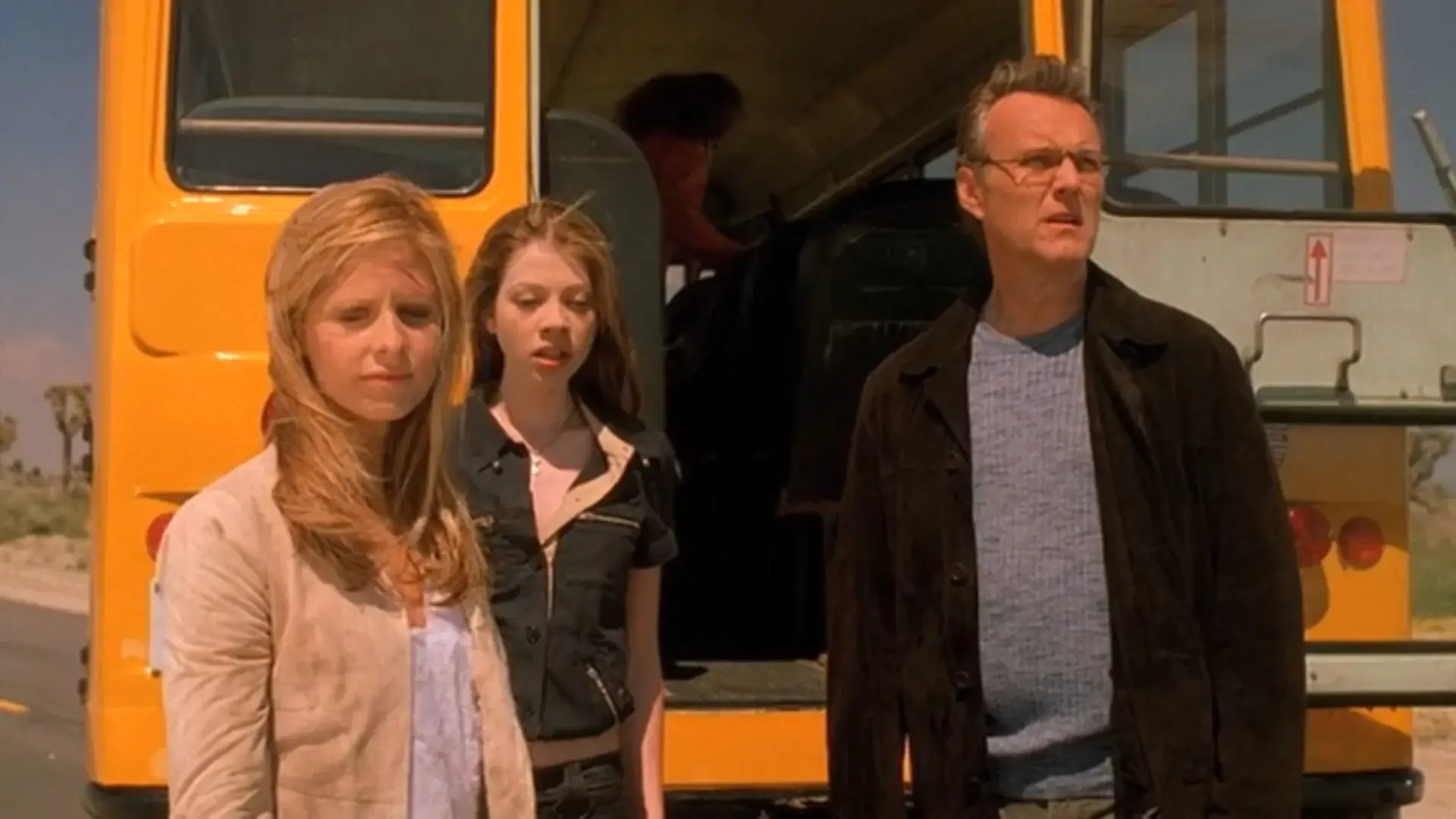 Sarah Michelle Gellar, Michelle Trachtenberg, and Anthony Stewart Head stand somberly in front of a school bus in Buffy The Vampire Slayer - Season 7, Episode 22 - "Chosen."