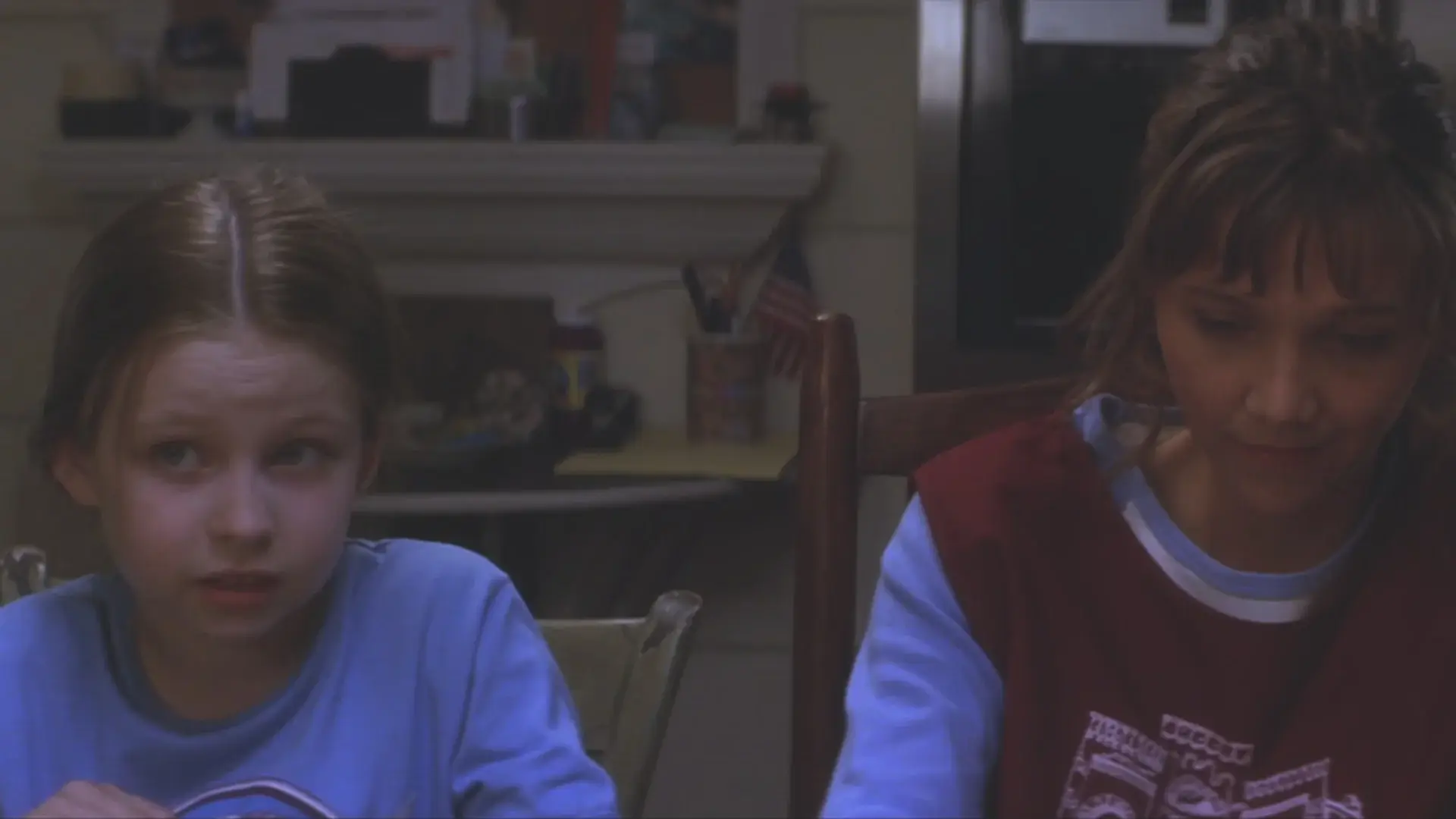 A curious Daveigh Chase asks a question while Maggie Gyllenhaal sits next to her in Donnie Darko.