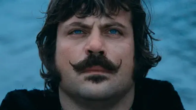 Oliver Reed looks up with foreboding while standing in front of the water in Ken Russell's The Devils.