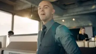 Nicholas Hoult stands with a cocky smile in the LuthorCorp control room in Superman.