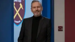 A bearded Anthony Stewart Head stands in a doorway with a smile in Ted Lasso, Season 3 Episode 4 - "Big Game."