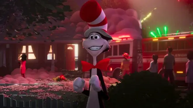 The Cat in the Hat stands in front of a wrecked house with a smile of optimism.