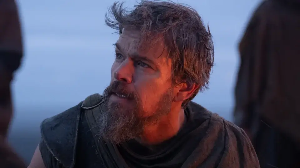 Matt Damon looks up with worry while bathed in fire light in The Odyssey.