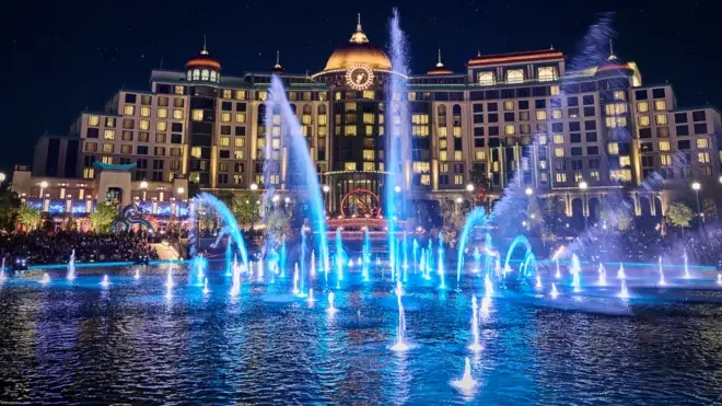 Celestial Park shown at night, lit up and with the fountains running, at Universal Epic Universe.