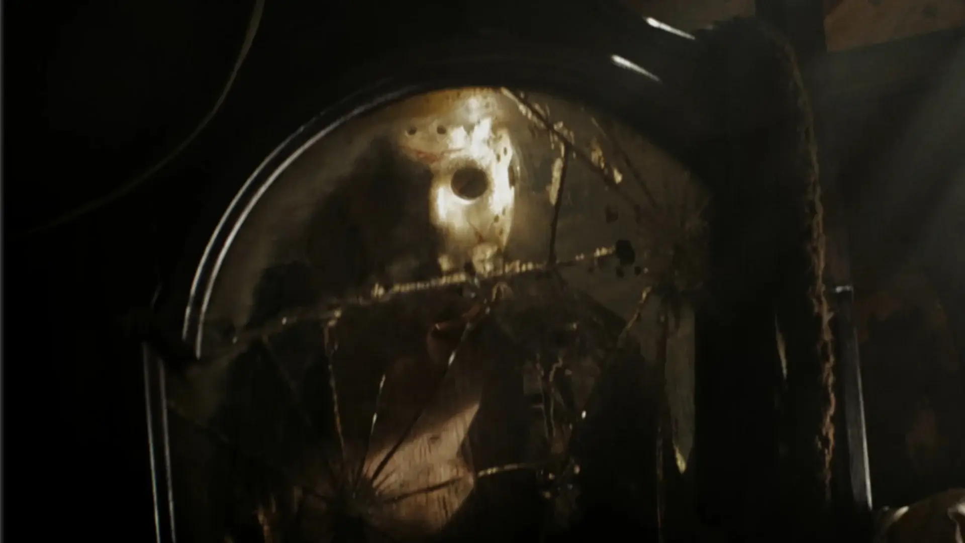 Jason Voorhees looks in a broken dirty mirror in a dimly lit room in Friday the 13th (2009).