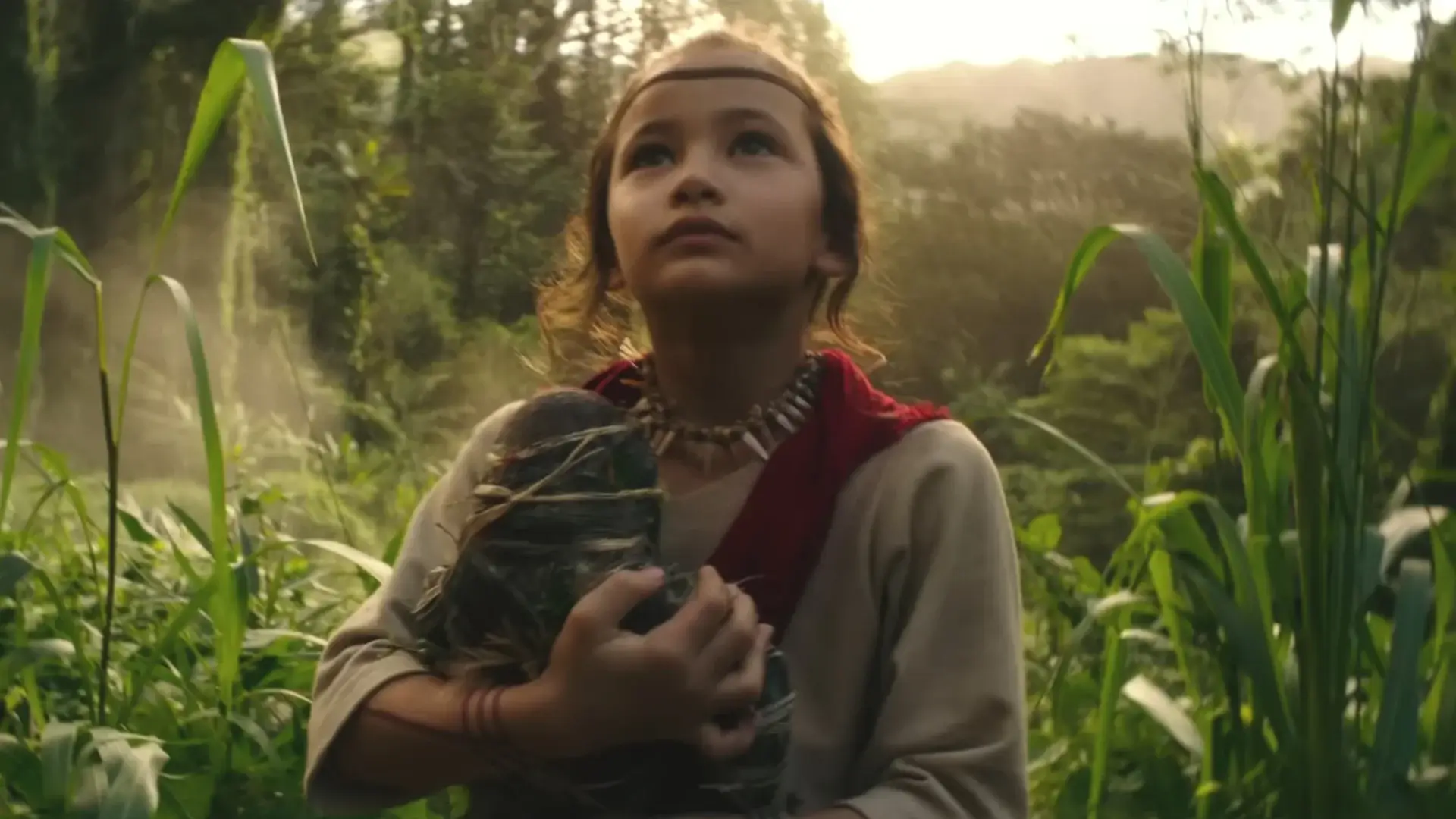 Kaylee Hottle stands in Skull Island with a Kong doll in her hands in Godzilla vs Kong.