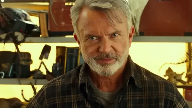 Sam Neill smiles mischievously in his tent during the day in Jurassic World Dominion.