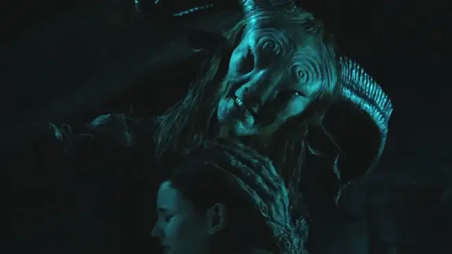 Doug Jones in full Fauno makeup embraces Ivana Baquero outside at night in Pan's Labyrinth.
