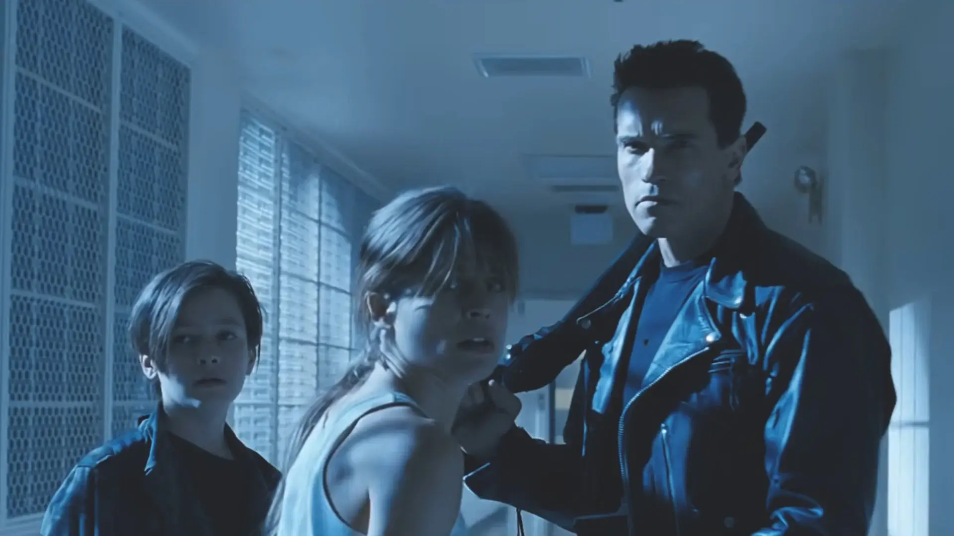 Edward Furlong and Linda Hamilton look on in horror as Arnold Schwarzenegger protects them in Terminator 2: Judgment Day.