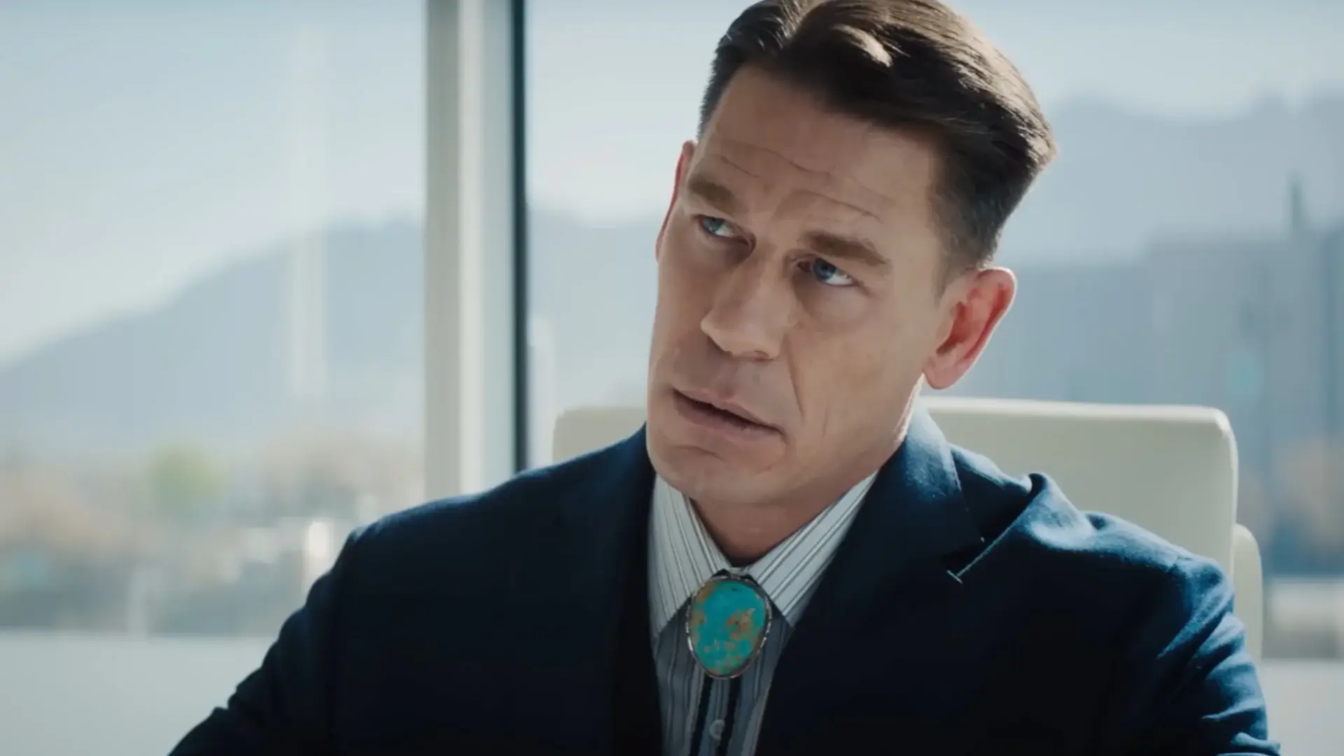 John Cena looks straight ahead in his office with a look of disbelief in Coyote vs. Acme.