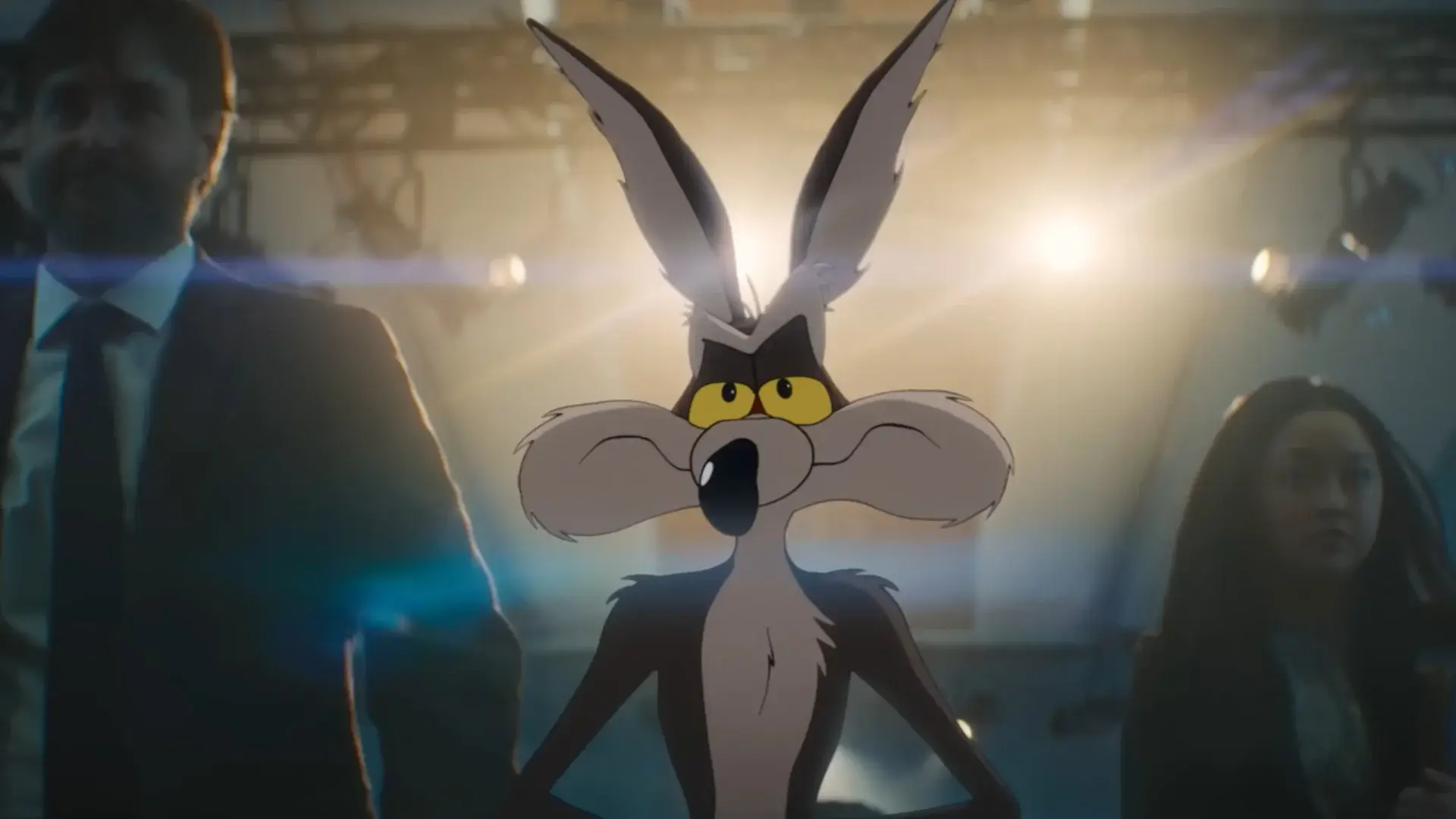 A confident Wile E Coyote walks away from harsh courtroom lighting flanked by Will Forte and Lana Condor in Coyote vs. Acme.