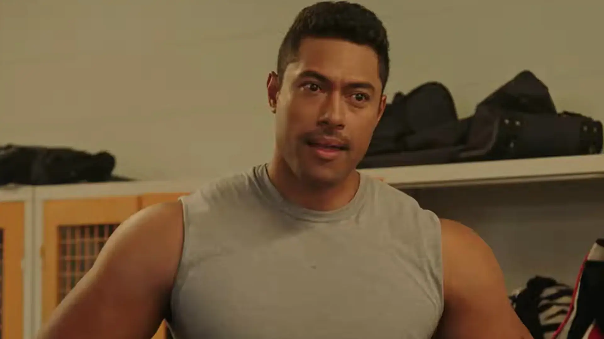 A curious Uli Latukefu stands in a locker room in Young Rock.