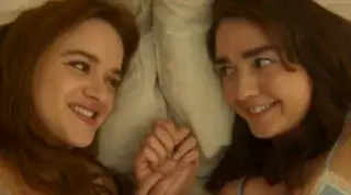 Joey King as Kiley Owens and Maisie Williams as Antonia Owens laying in bed together in Practical Magic 2